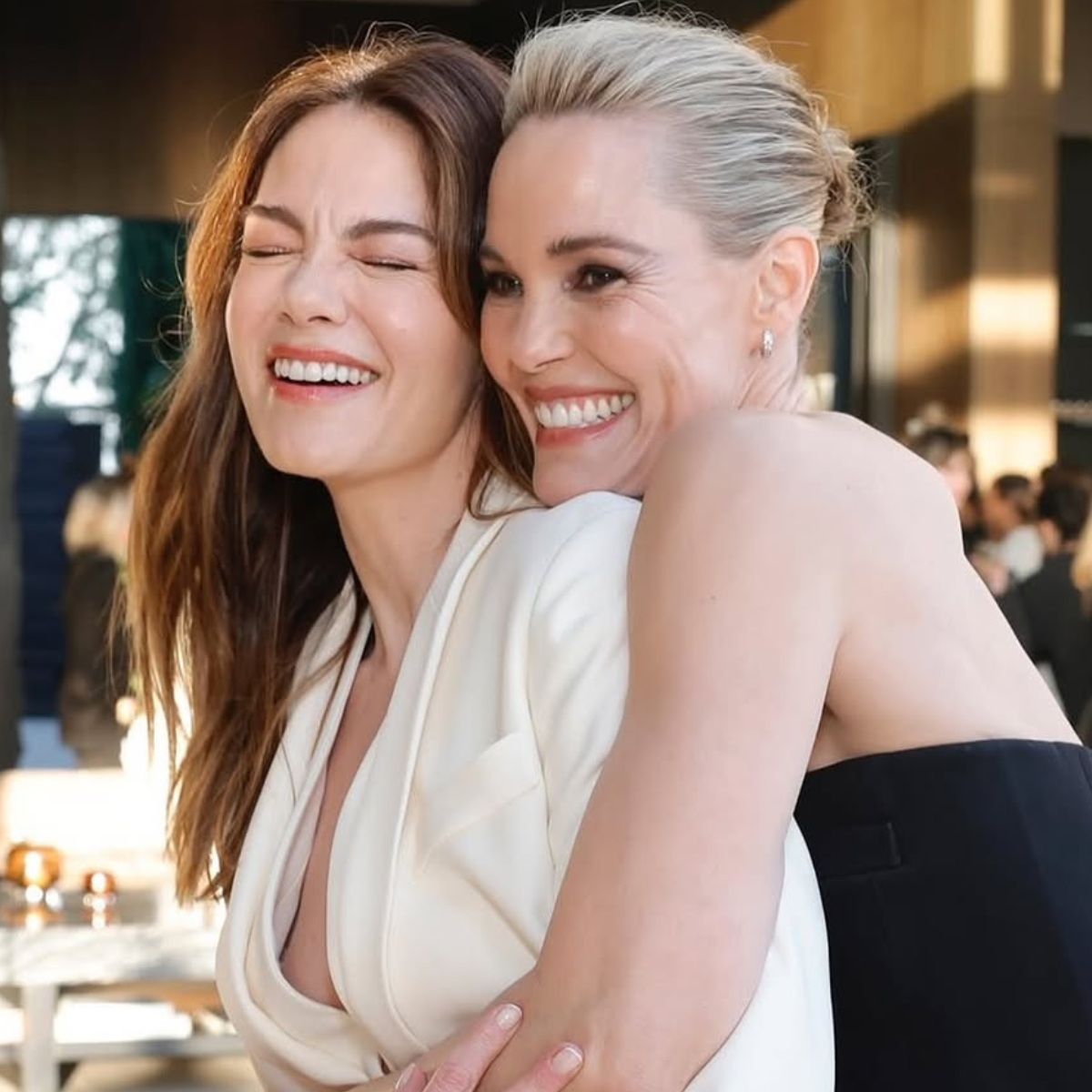 Michelle Monaghan and Leslie Bibb hugging, both showing off their new brunette and blonde looks