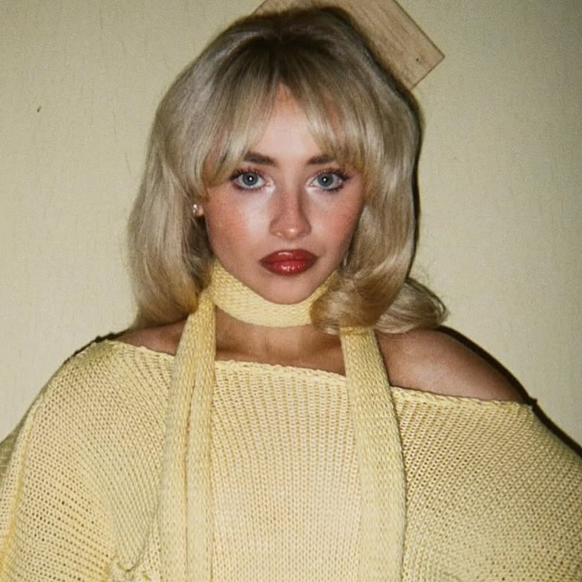 Sabrina Carpenter with voluminous buttery blonde curls and fringe, styled with retro flair in “Manchild.”