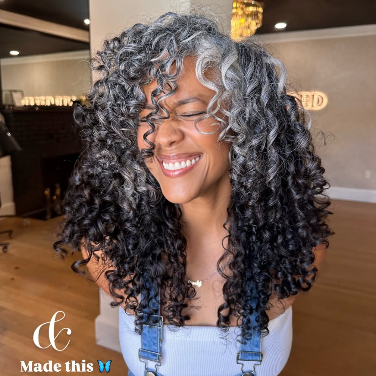 mid length smokey gray curls on a happy client with gray blended roots