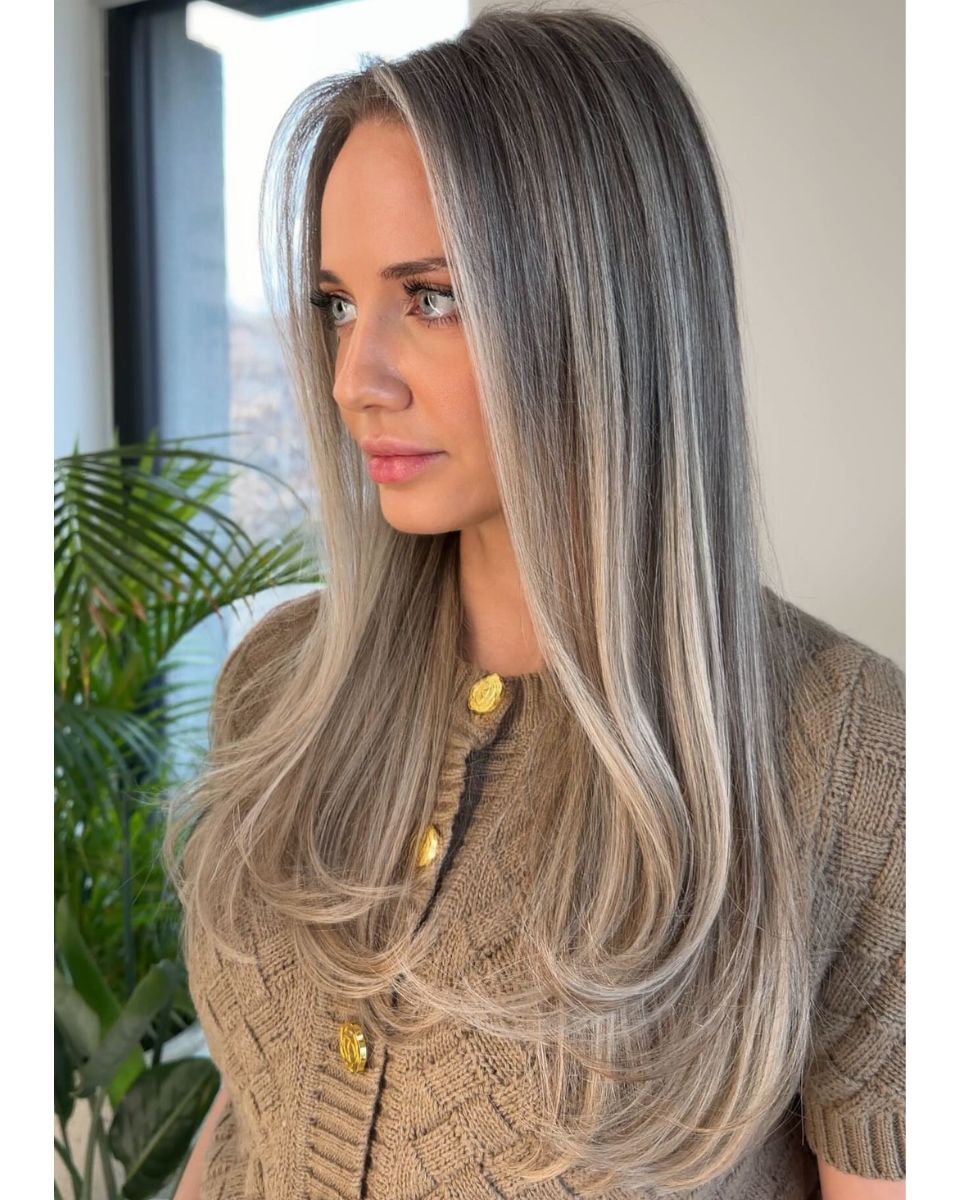Dimensional ash beige blonde with soft grey blending, face-framing brightness and long layered styling.